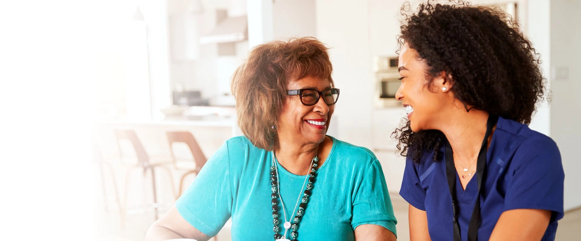 caregiver laughing with elderly woman